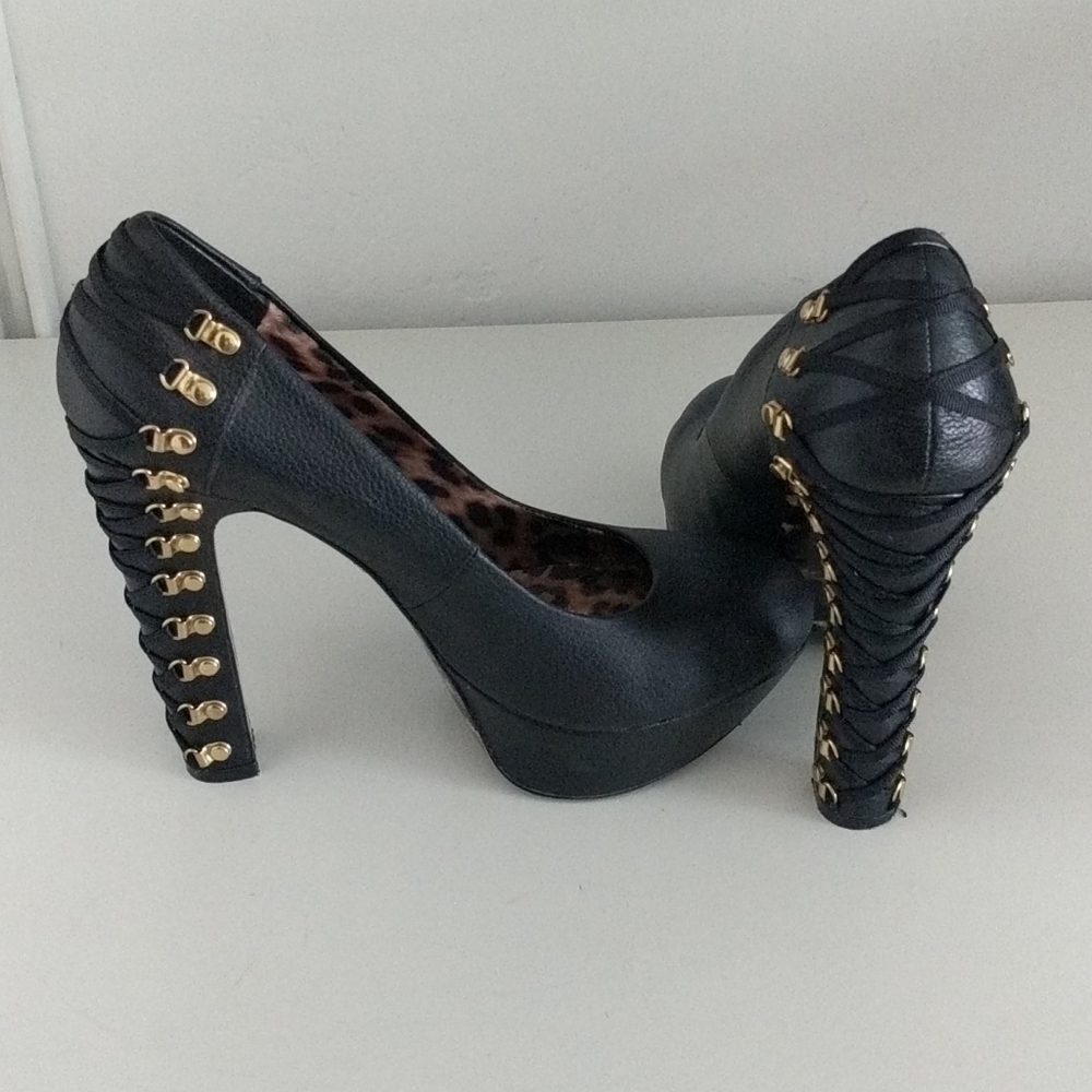 Black leather heels with gold cross clips.